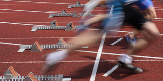 Startschuss Mehrere Sprinter nebeneinander starten aus Startblöcken.
